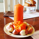 orange candle and painted stones centerpiece